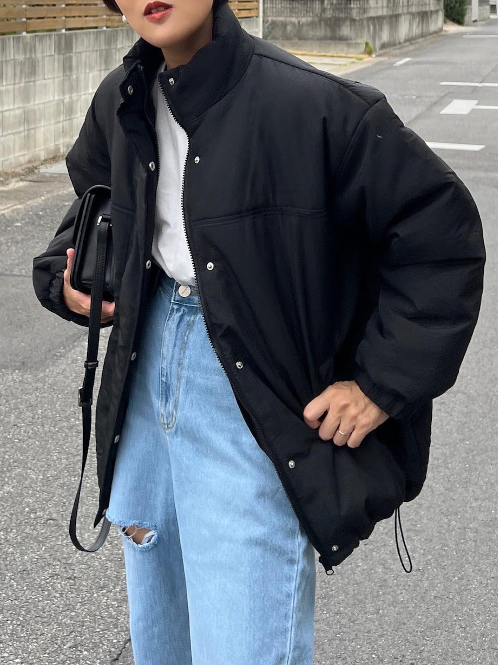 ブラック系のダウンジャケット/コート、ブラック系のショルダーバッグ、ブラック系のローファーを着用したレディースの秋コーディネートの4枚目の写真