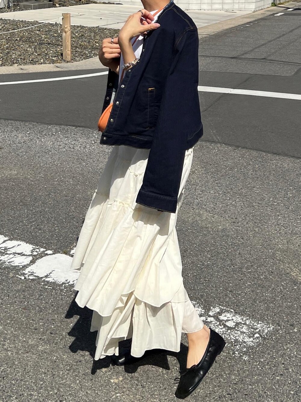 ブルー系のデニムジャケット、ホワイト系のTシャツ/カットソー、ホワイト系のスカートを着用したレディースの春コーディネートの2枚目の写真