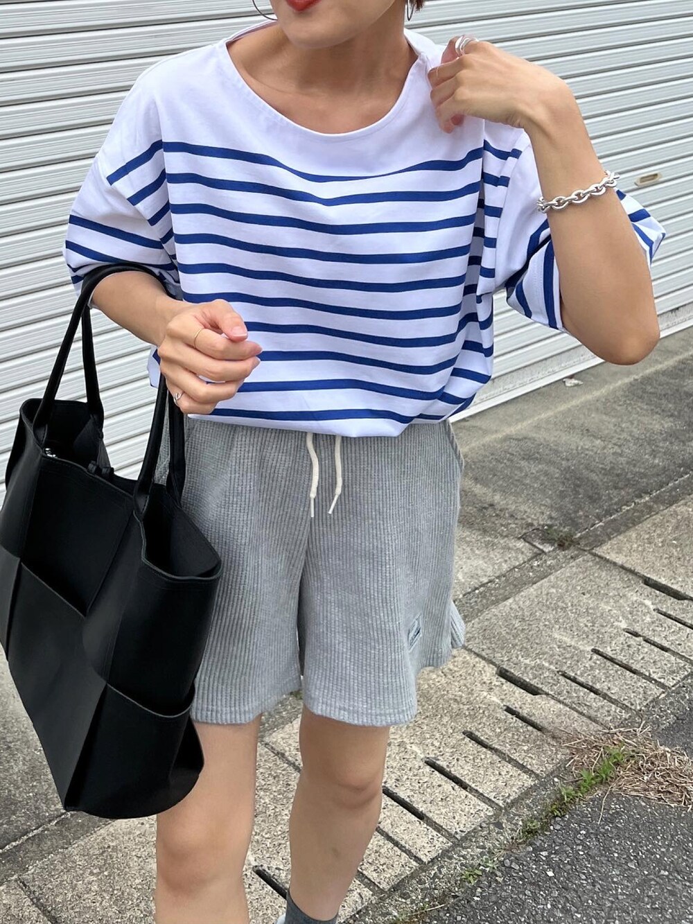 ブルー系のTシャツ/カットソー、グレー系のスニーカーを着用したレディースの春コーディネートの2枚目の写真