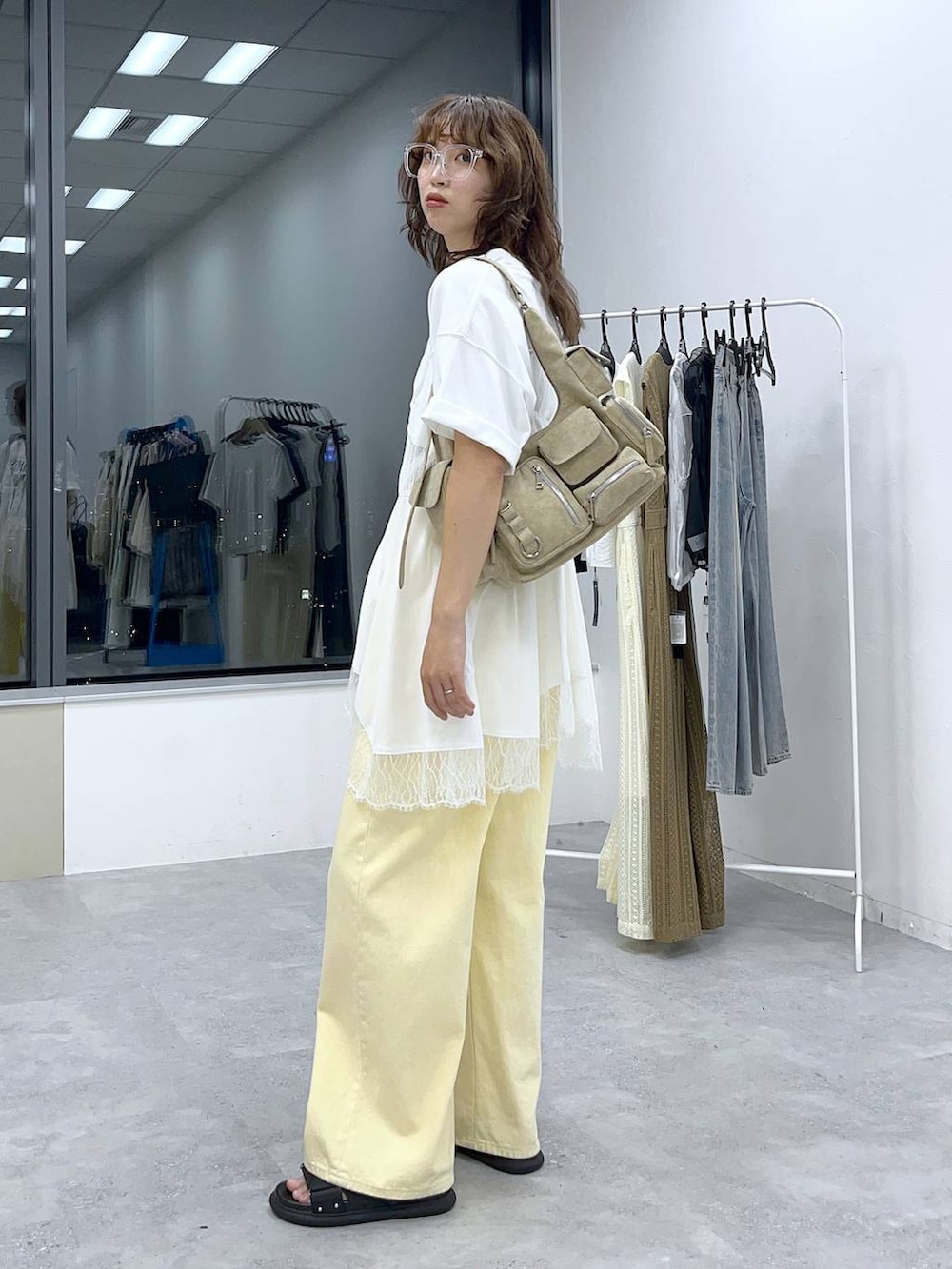 イエロー系のデニムパンツ、ホワイト系のキャミソール、ホワイト系のTシャツ/カットソーを着用したレディースの夏コーディネートの2枚目の写真