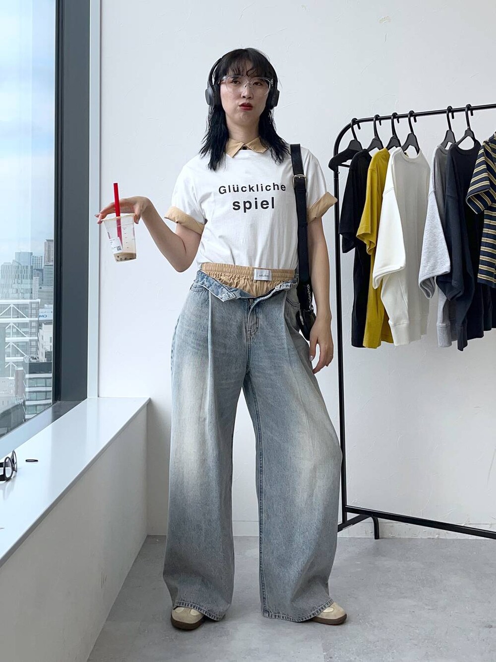 ブルー系のデニムパンツ、ホワイト系のTシャツ/カットソー、ブラック系のショルダーバッグを着用したレディースの夏コーディネートの2枚目の写真