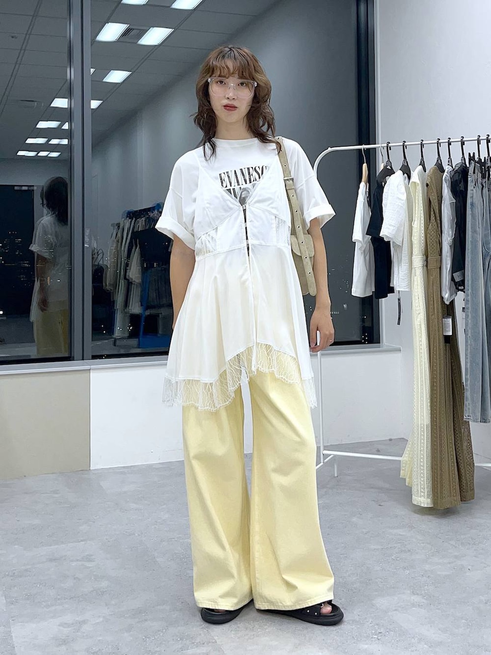 イエロー系のデニムパンツ、ホワイト系のキャミソール、ホワイト系のTシャツ/カットソーを着用したレディースの夏コーディネートの3枚目の写真
