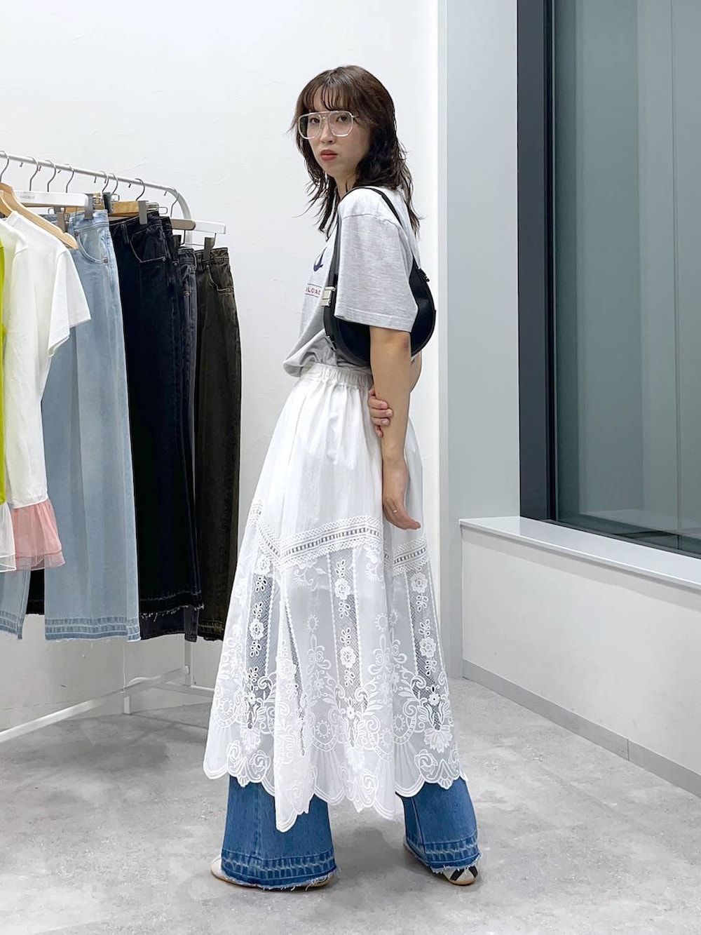 ブラック系のショルダーバッグ、ブルー系のデニムパンツ、その他のTシャツ/カットソーを着用したレディースの夏コーディネートの4枚目の写真