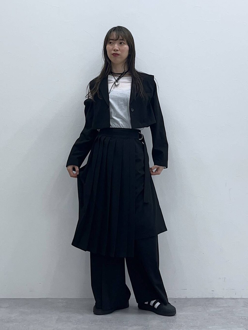 ブラック系のスラックス、ブラック系のスカート、ホワイト系のTシャツ/カットソーを着用したレディースの春コーディネートの3枚目の写真
