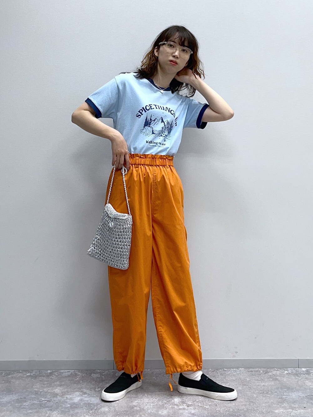 ブルー系のTシャツ/カットソー、オレンジ系のその他パンツ、グレー系のショルダーバッグを着用したレディースの春コーディネートの3枚目の写真