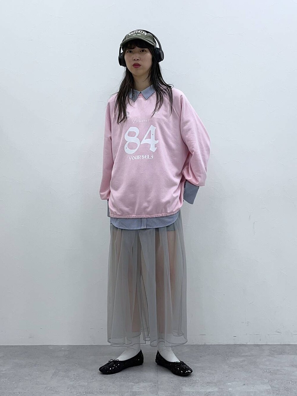 ピンク系のスウェット、グレー系のスカート、ブラック系のバレエシューズを着用したレディースの春コーディネートの3枚目の写真