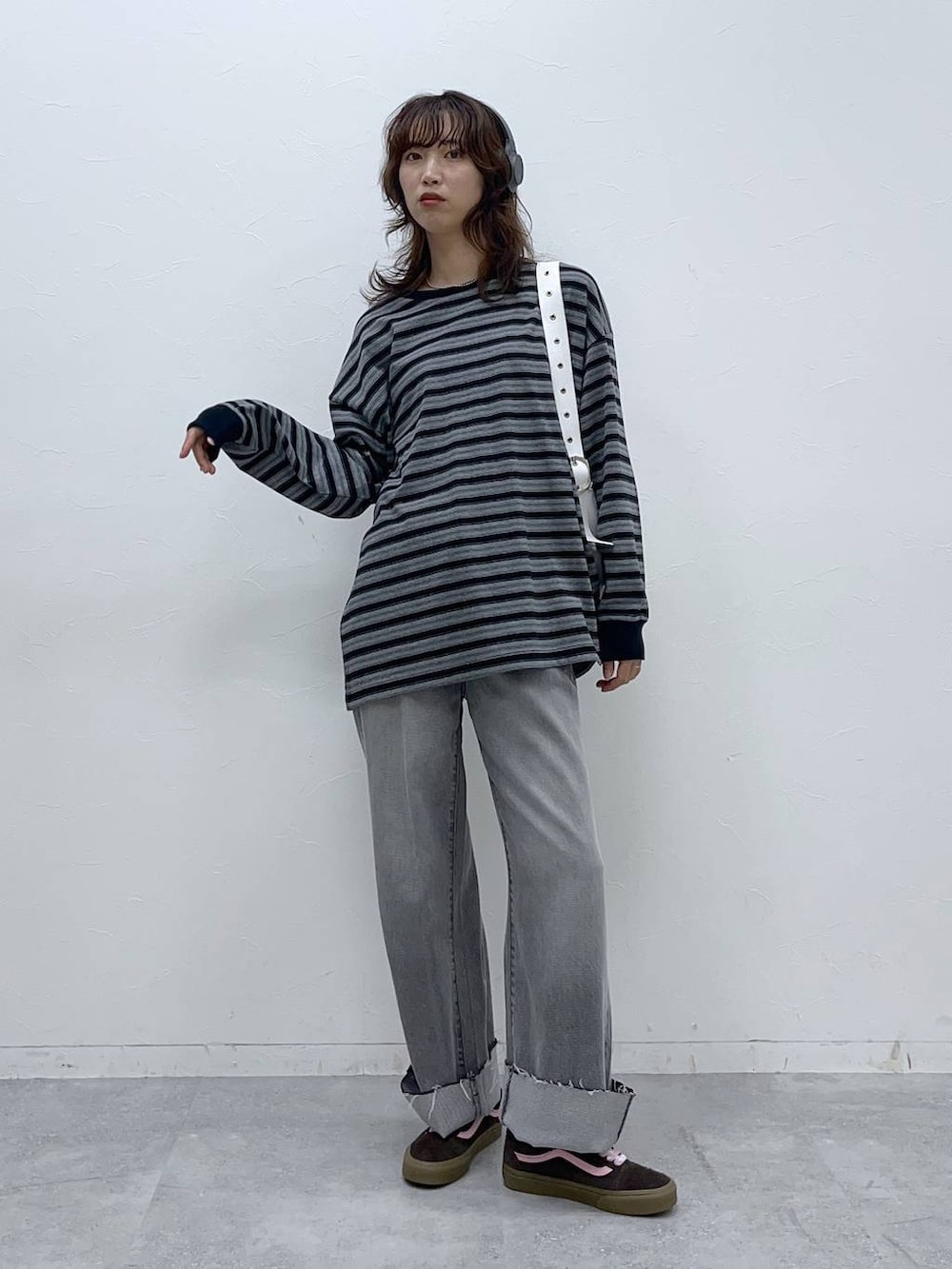 ホワイト系のショルダーバッグ、グレー系のデニムパンツ、ブラック系のTシャツ/カットソーを着用したレディースの秋コーディネートの3枚目の写真