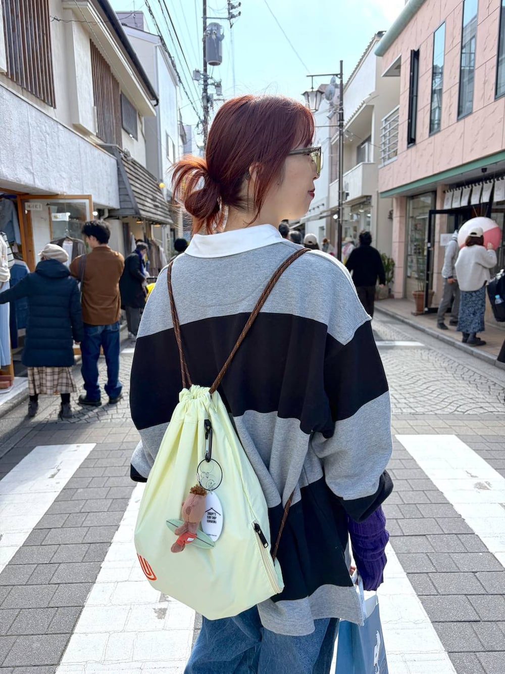 グレー系のポロシャツを着用したレディースの春コーディネートの3枚目の写真