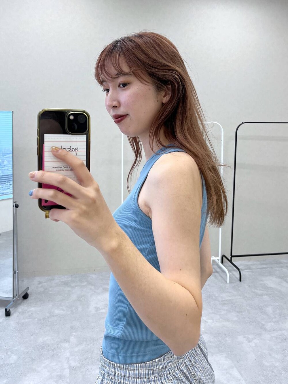 ブルー系のタンクトップを着用したレディースの春コーディネートの2枚目の写真