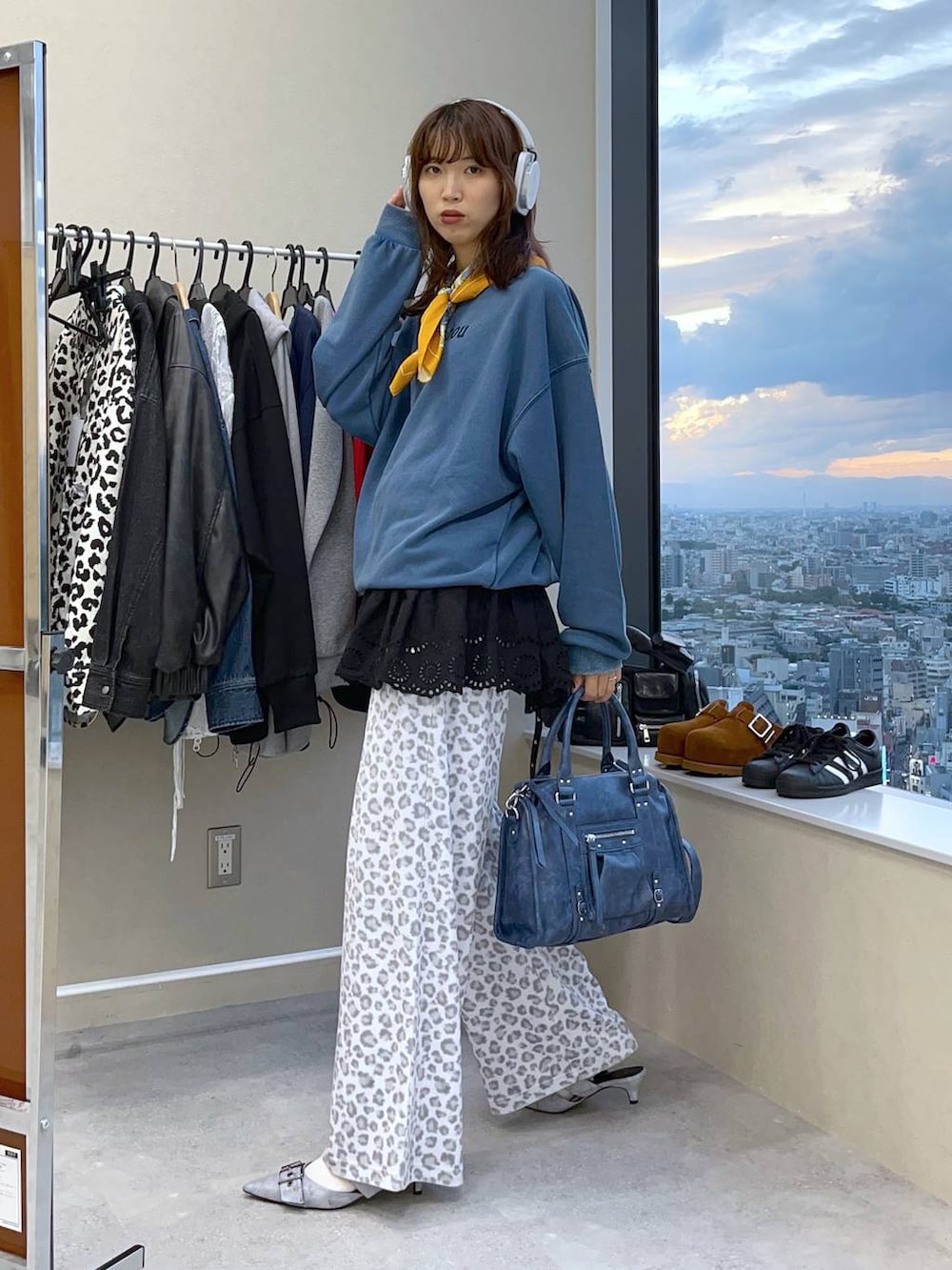 ブルー系のボストンバッグ、グレー系のパンプス、ホワイト系のその他パンツを着用したレディースの秋コーディネートの2枚目の写真