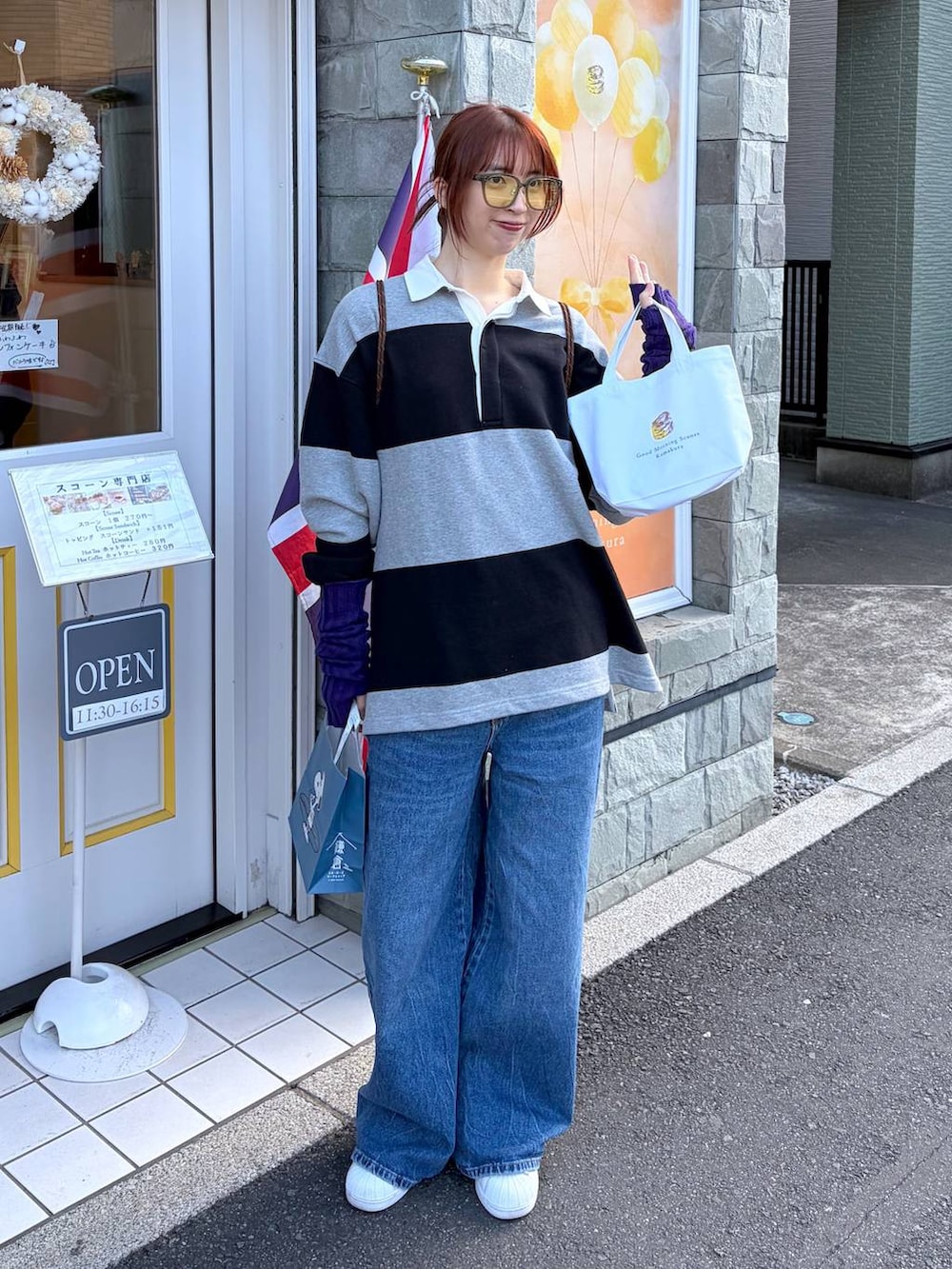 グレー系のポロシャツを着用したレディースの春コーディネートの2枚目の写真