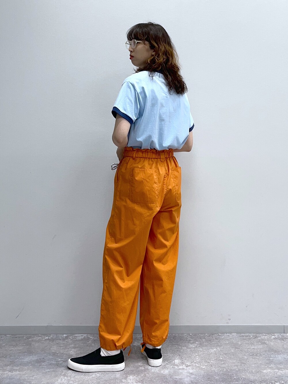 ブルー系のTシャツ/カットソー、オレンジ系のその他パンツ、グレー系のショルダーバッグを着用したレディースの春コーディネートの2枚目の写真