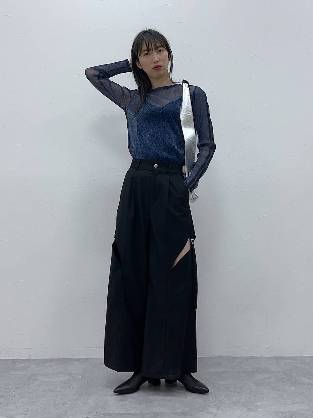 シルバー系のトートバッグ、ブラック系のブーツ、ブラック系のその他パンツを着用したレディースの春コーディネートの3枚目の写真