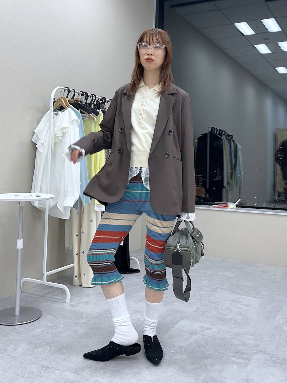 ホワイト系のシャツ/ブラウス、ブラウン系のテーラードジャケット、グリーン系のボストンバッグを着用したレディースの冬コーディネートの4枚目の写真