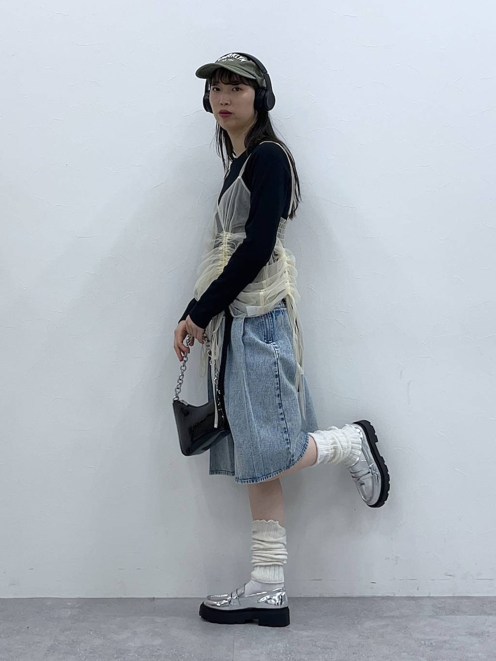 ブラック系のTシャツ/カットソー、ホワイト系のワンピース、ブルー系のデニムスカートを着用したレディースの春コーディネートの2枚目の写真