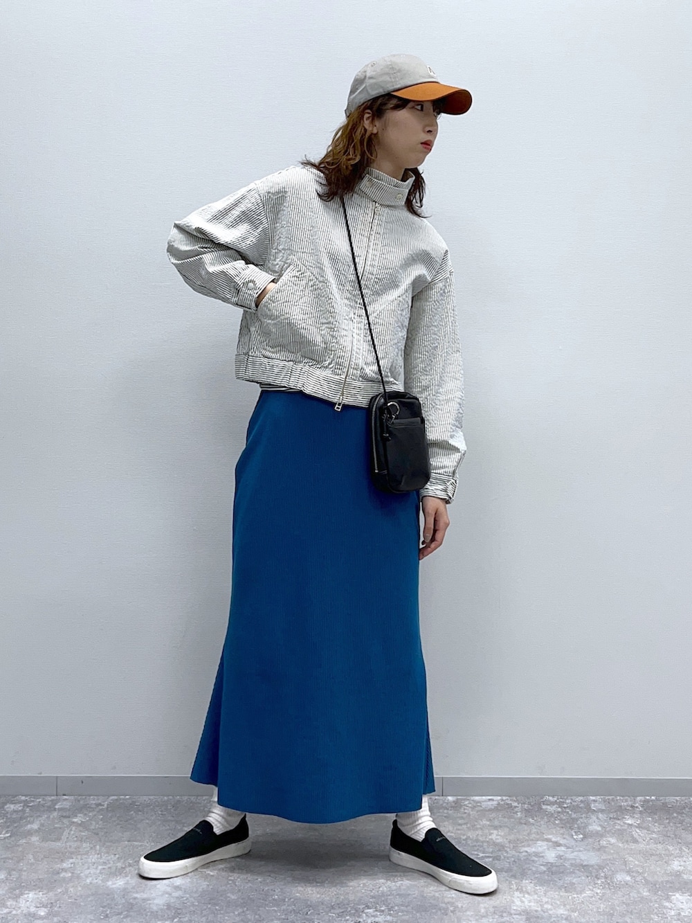 ブルー系のブルゾン、ブルー系のスカート、ブラック系のスニーカーを着用したレディースの春コーディネートの2枚目の写真