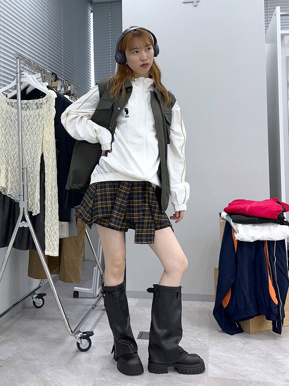 ブラック系のブーツ、イエロー系のその他パンツ、グリーン系のベストを着用したレディースの冬コーディネートの3枚目の写真