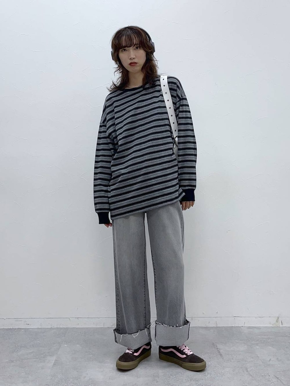 ホワイト系のショルダーバッグ、グレー系のデニムパンツ、ブラック系のTシャツ/カットソーを着用したレディースの秋コーディネートの2枚目の写真