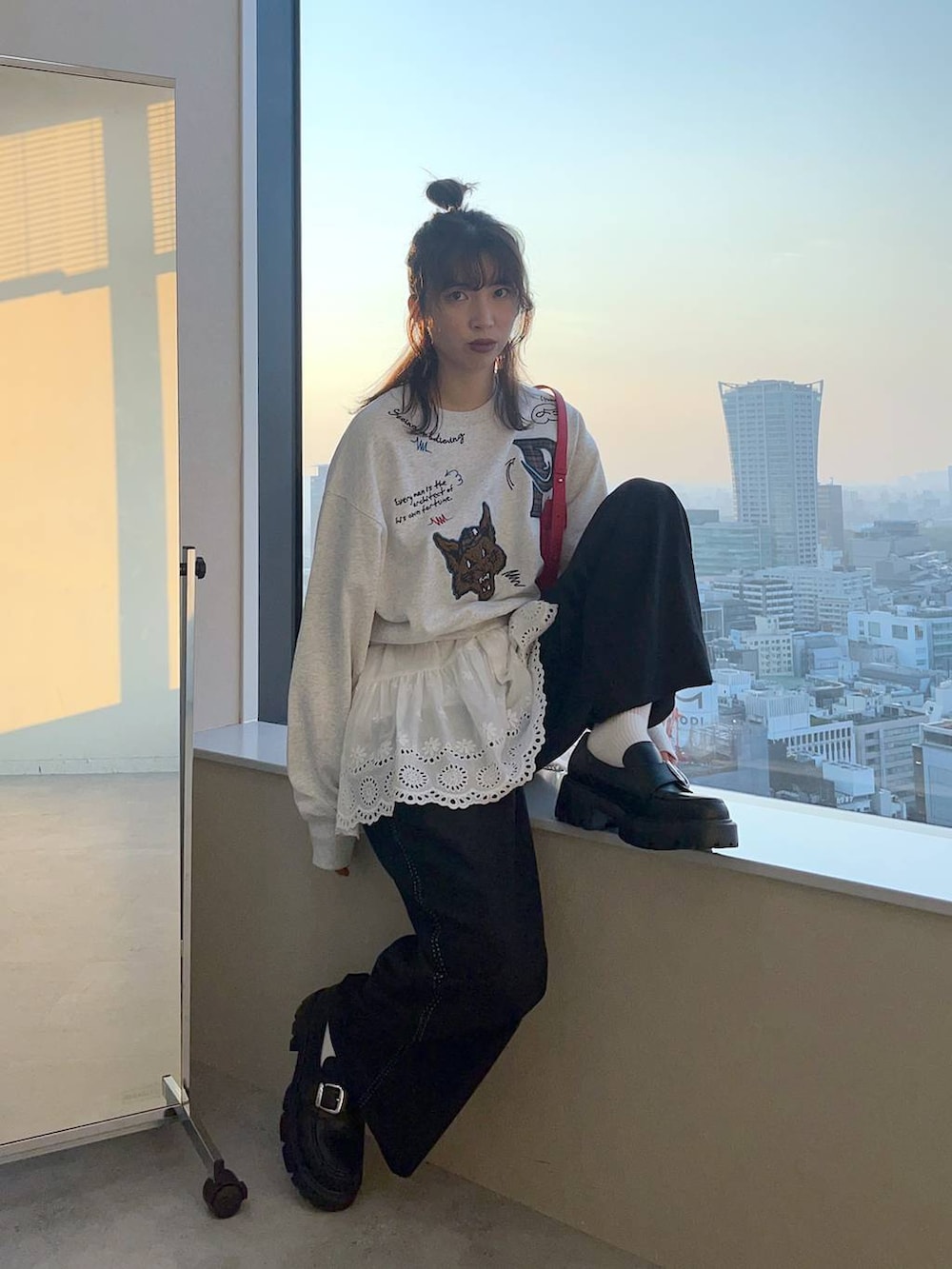 レッド系のショルダーバッグを着用したレディースの秋コーディネートの2枚目の写真