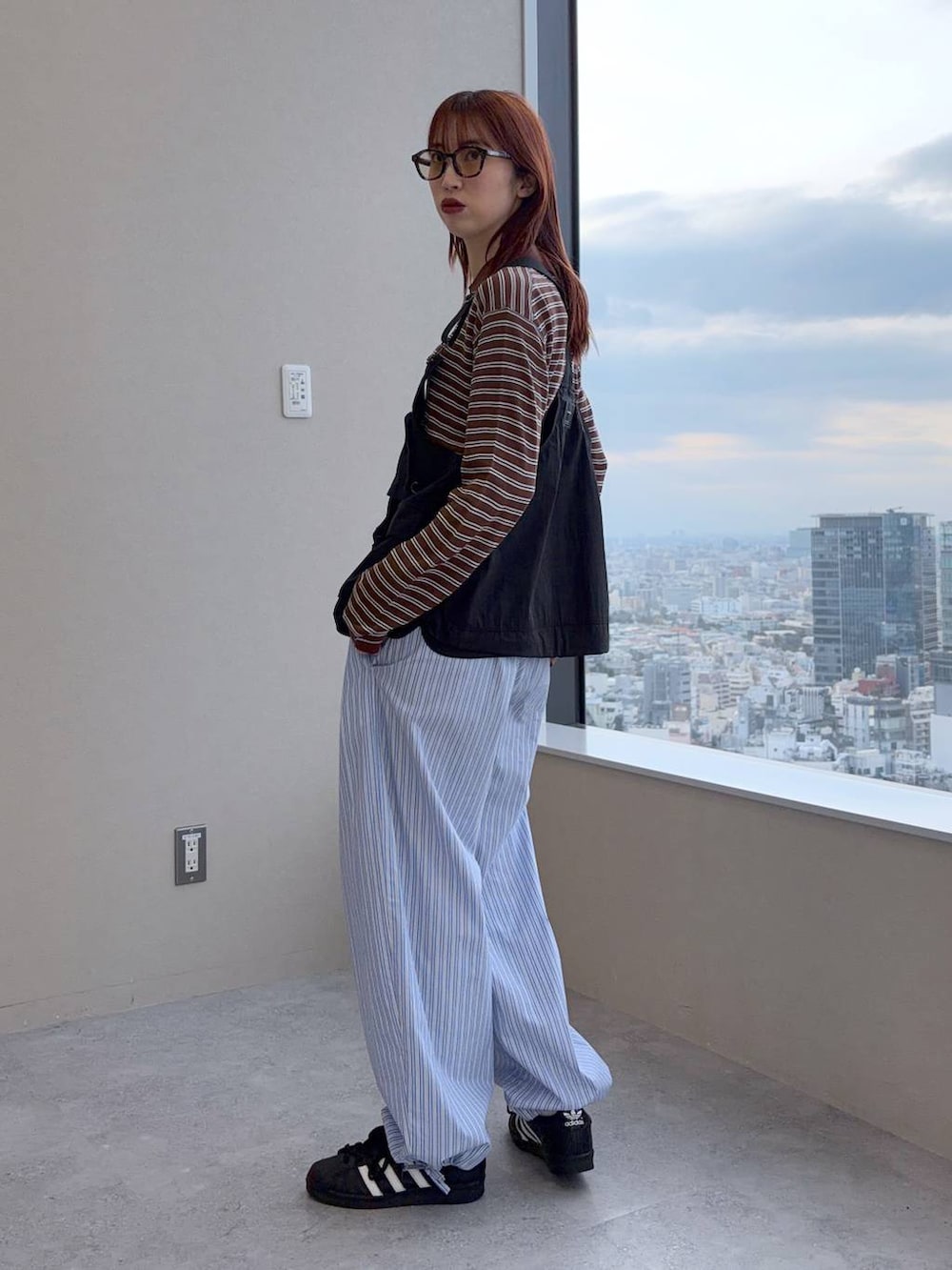 ブラウン系のポロシャツを着用したレディースの春コーディネートの5枚目の写真