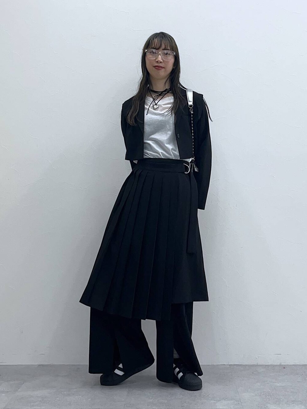 ブラック系のスラックス、ブラック系のスカート、ホワイト系のTシャツ/カットソーを着用したレディースの春コーディネートの5枚目の写真