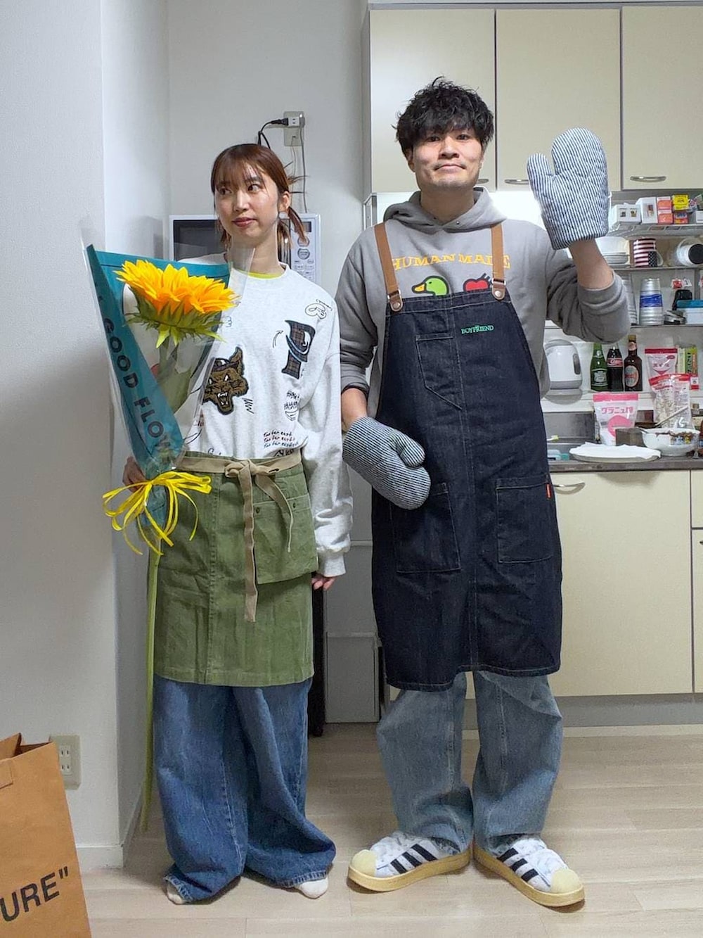 ブルー系のエプロンを着用したレディースの春コーディネートの2枚目の写真