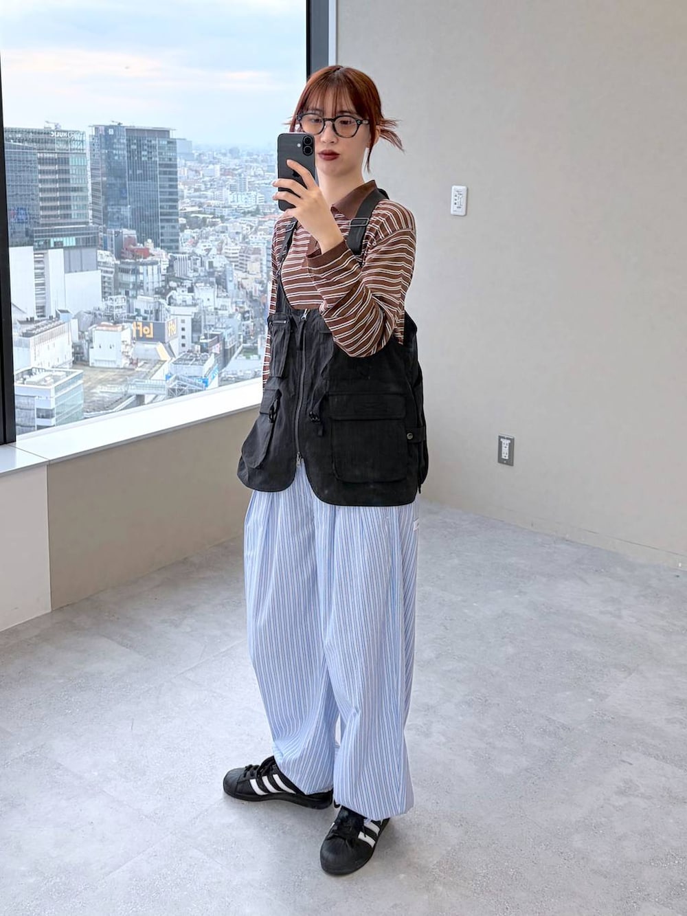 ブラウン系のポロシャツを着用したレディースの春コーディネートの2枚目の写真