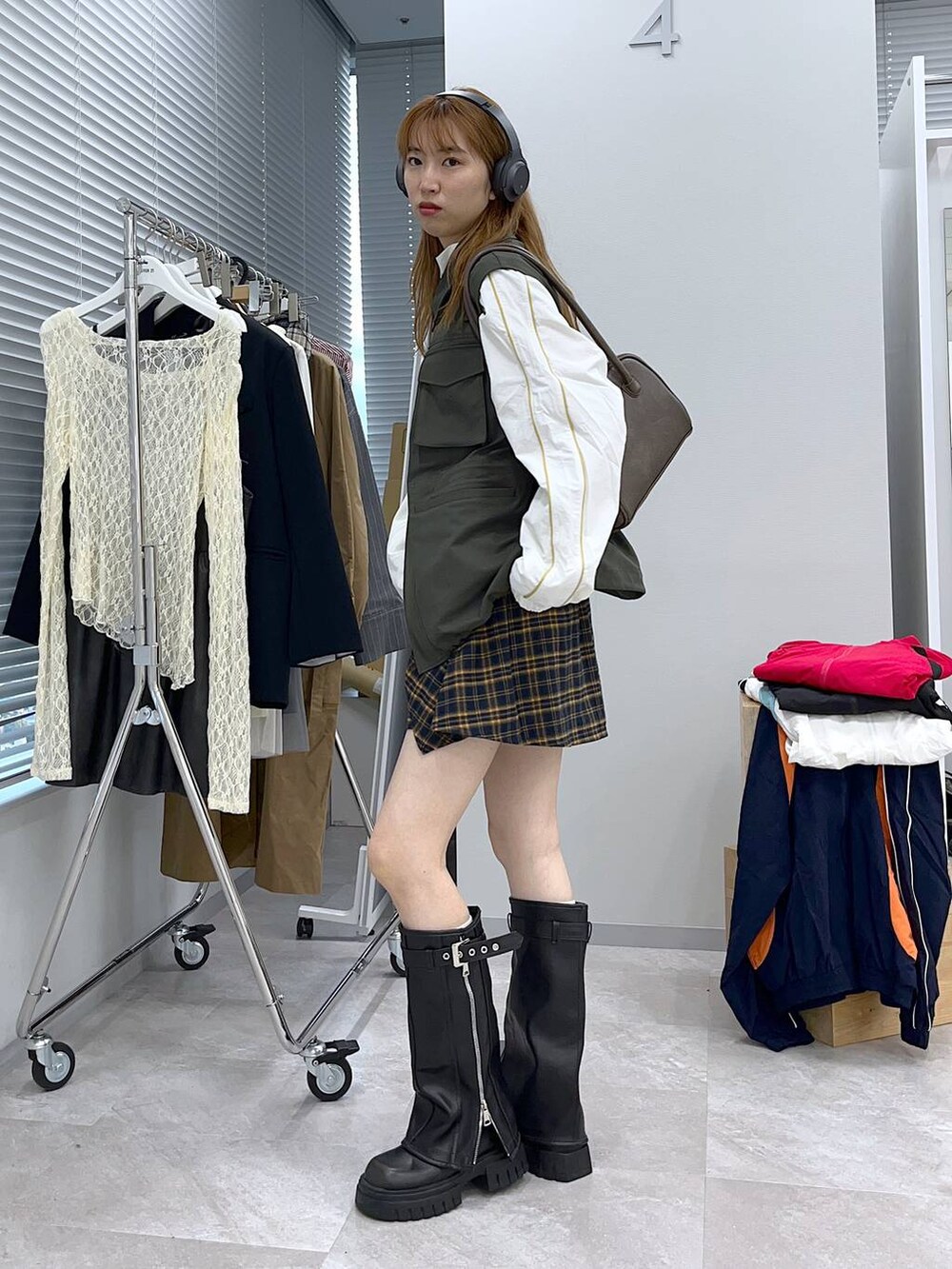 ブラック系のブーツ、イエロー系のその他パンツ、グリーン系のベストを着用したレディースの冬コーディネートの2枚目の写真