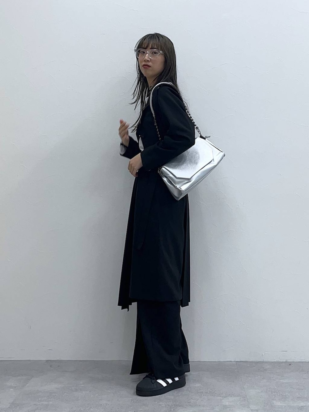 ブラック系のスラックス、ブラック系のスカート、ホワイト系のTシャツ/カットソーを着用したレディースの春コーディネートの2枚目の写真