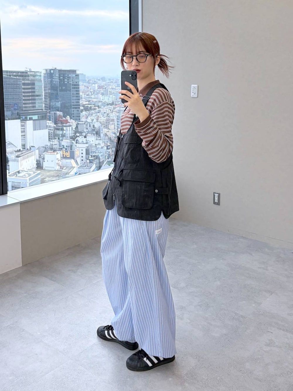 ブラウン系のポロシャツを着用したレディースの春コーディネートの7枚目の写真