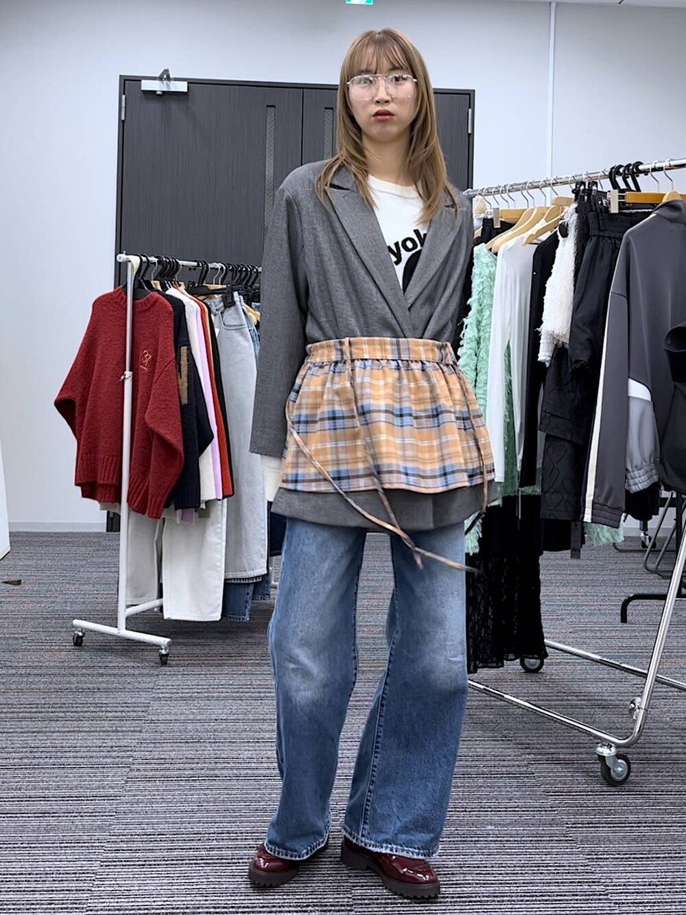 グレー系のテーラードジャケット、イエロー系のメガネを着用したレディースの冬コーディネートの3枚目の写真