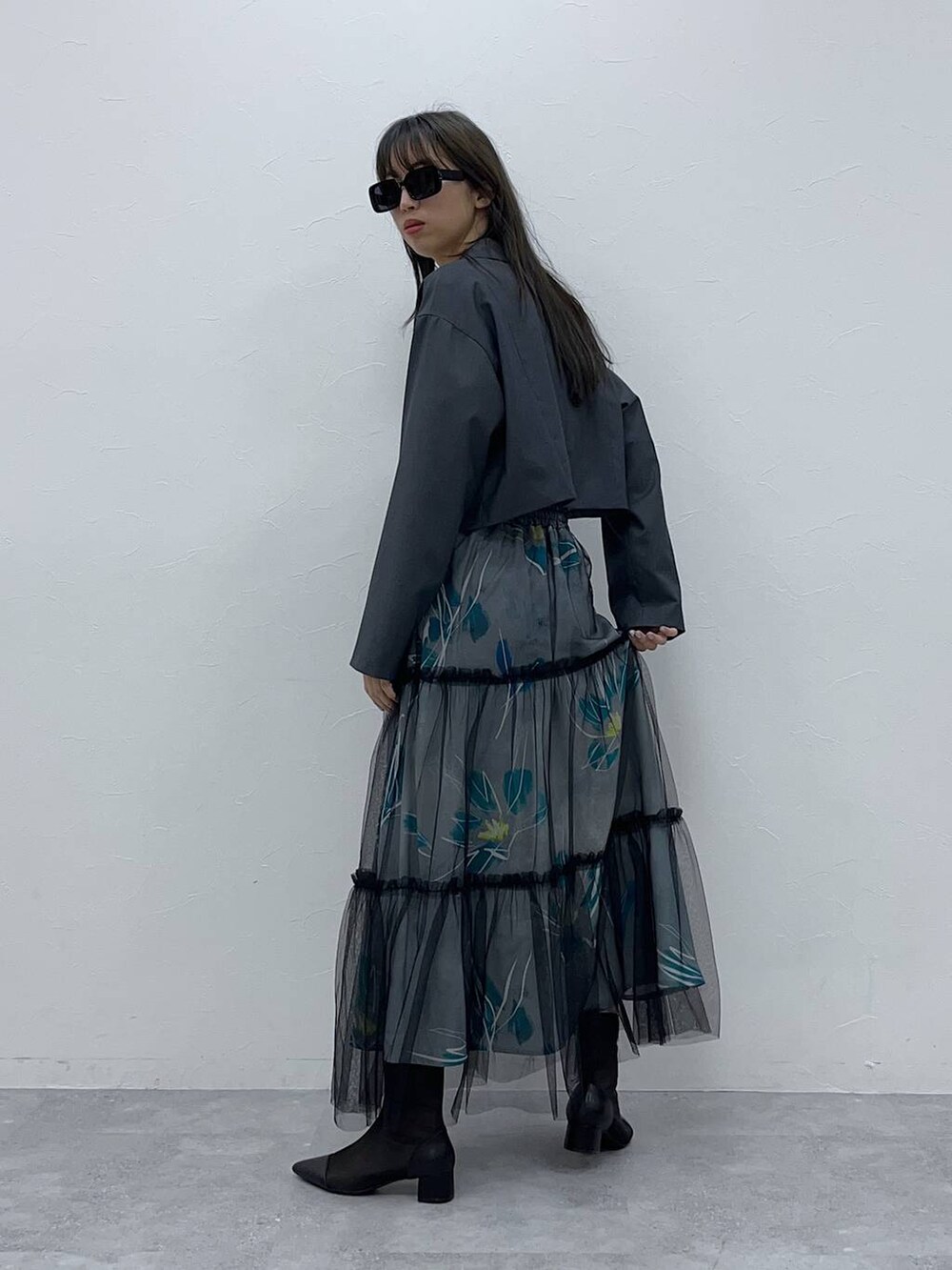 ブラック系のブーツ、ブラック系のサングラスを着用したレディースの春コーディネートの2枚目の写真