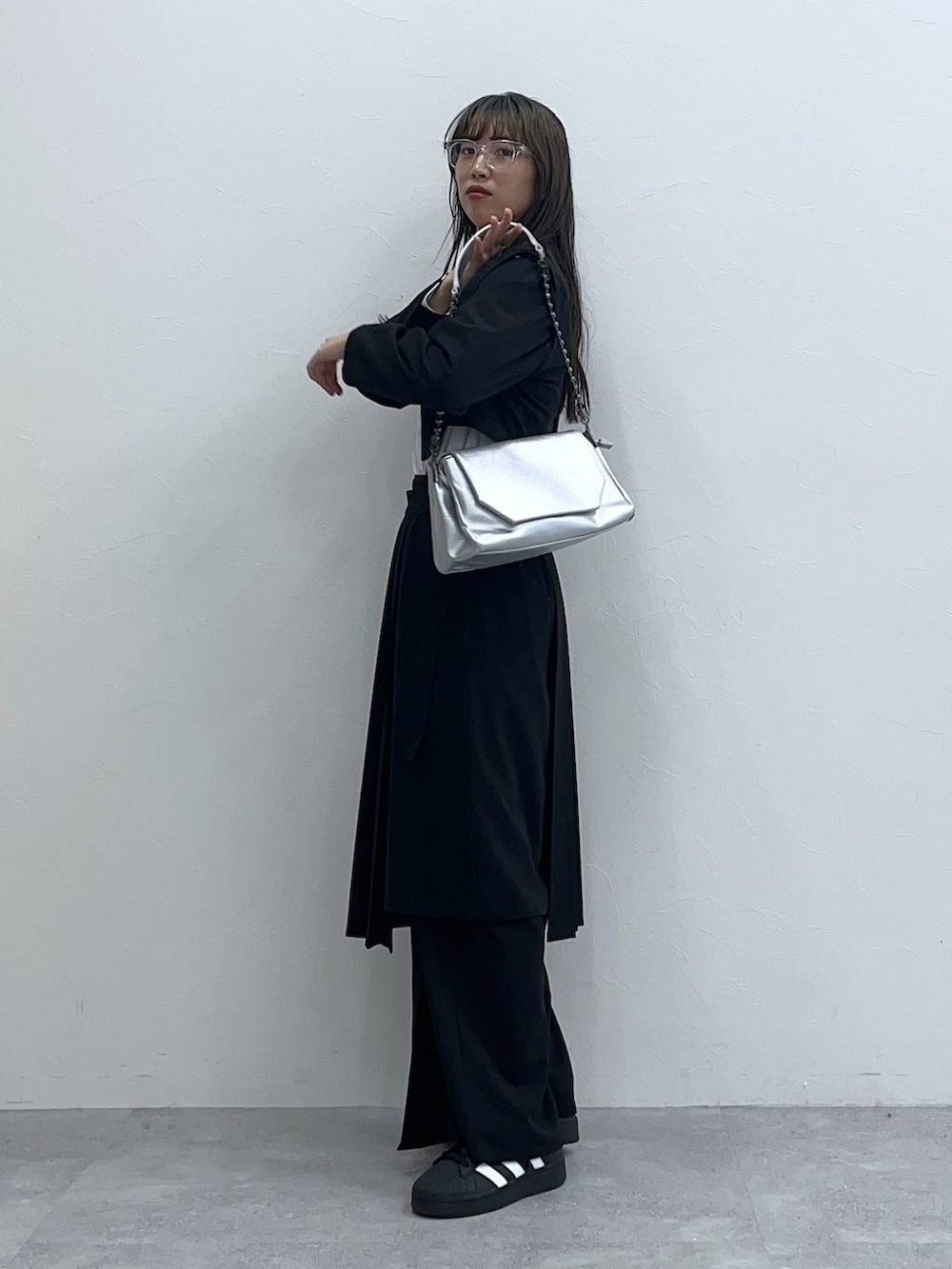 ブラック系のスラックス、ブラック系のスカート、ホワイト系のTシャツ/カットソーを着用したレディースの春コーディネートの4枚目の写真