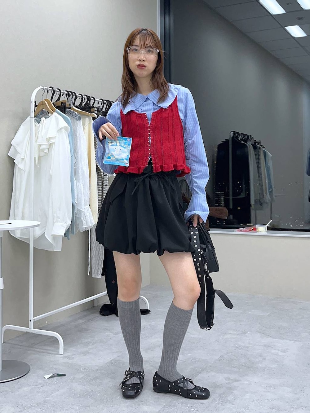 ブラック系のスカート、ブラック系のボストンバッグ、ブラック系のドレスシューズを着用したレディースの冬コーディネートの3枚目の写真