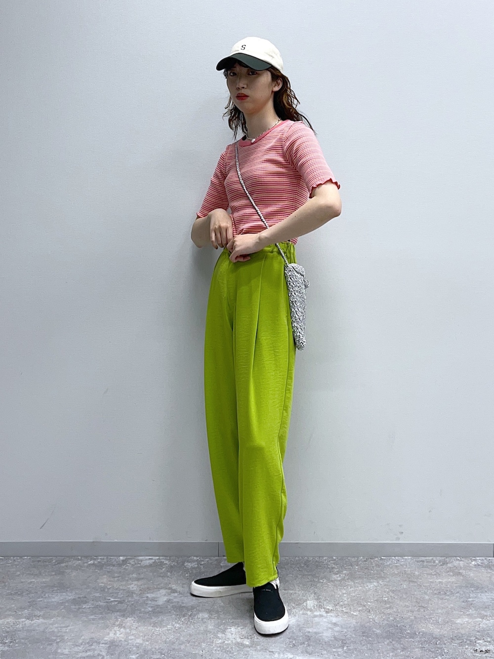 ピンク系のTシャツ/カットソー、グレー系のショルダーバッグ、ブラック系のスニーカーを着用したレディースの春コーディネートの3枚目の写真