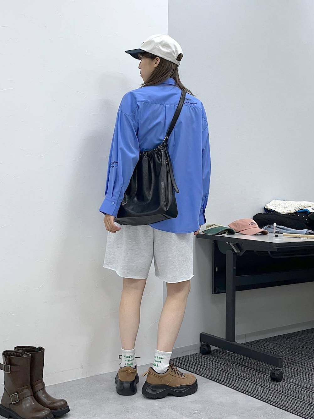 ブルー系のシャツ/ブラウス、グレー系のスウェットパンツ、ブラック系のショルダーバッグを着用したレディースの秋コーディネートの2枚目の写真
