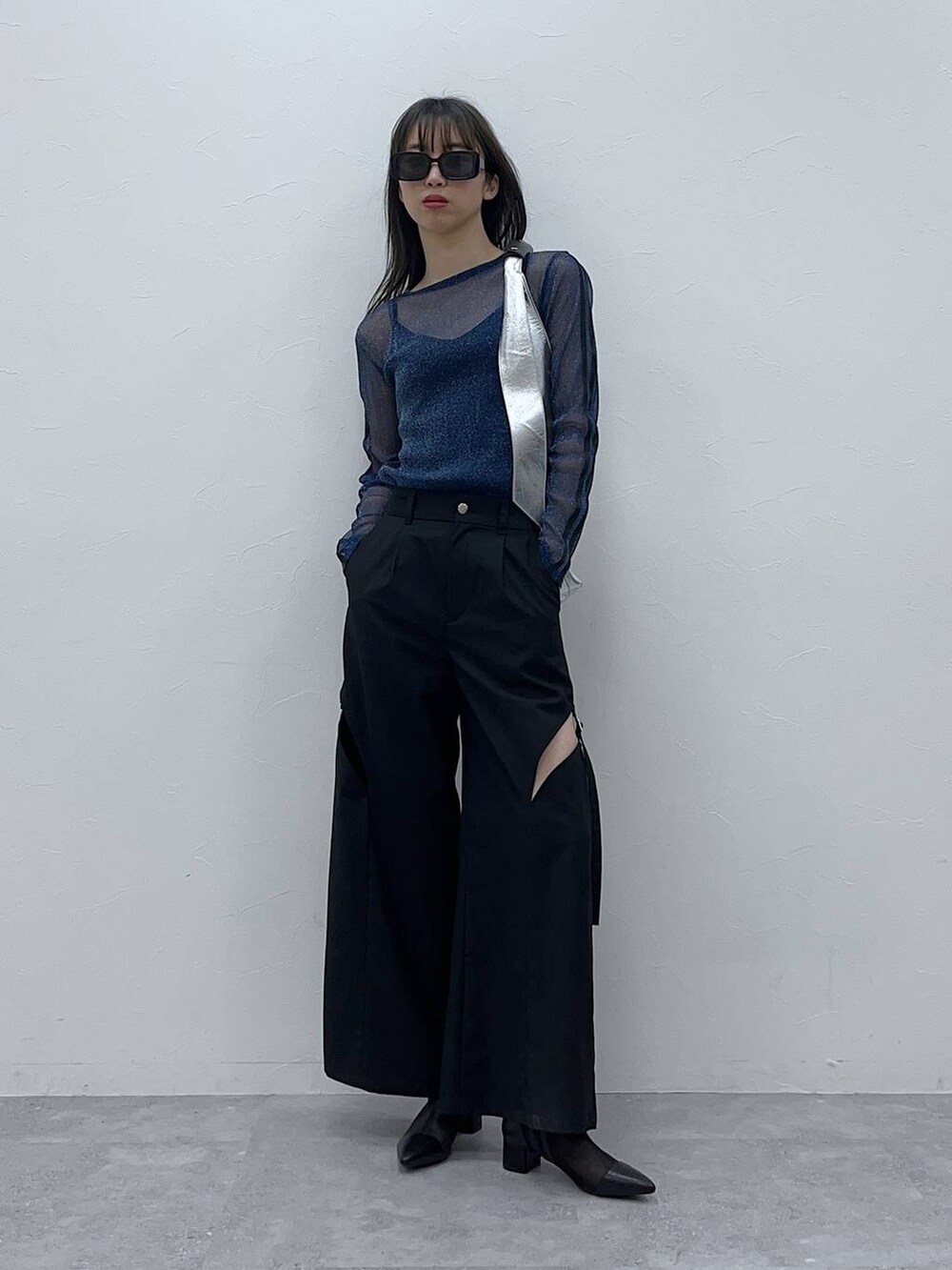 シルバー系のトートバッグ、ブラック系のブーツ、ブラック系のその他パンツを着用したレディースの春コーディネートの2枚目の写真