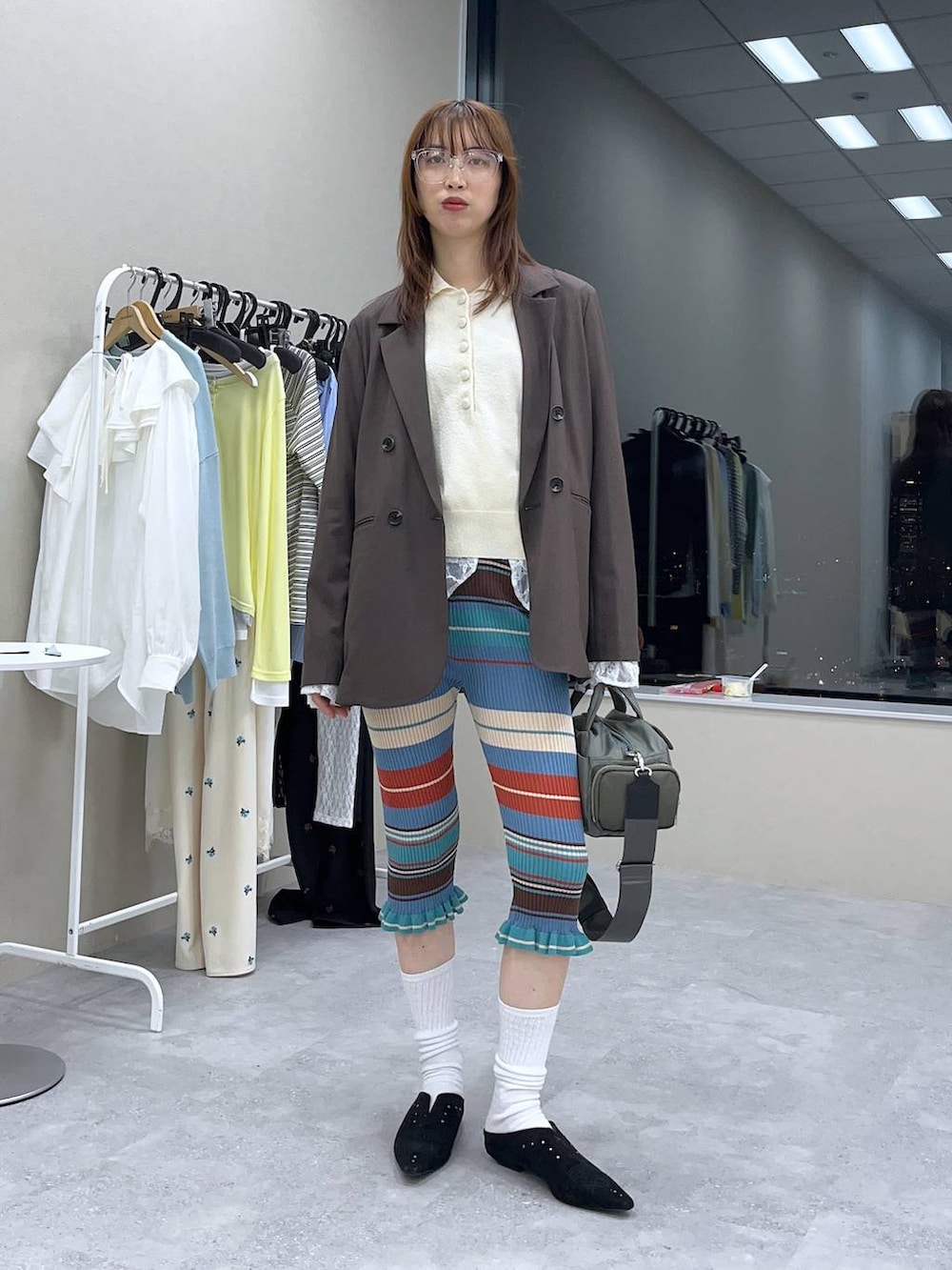 ホワイト系のシャツ/ブラウス、ブラウン系のテーラードジャケット、グリーン系のボストンバッグを着用したレディースの冬コーディネートの3枚目の写真