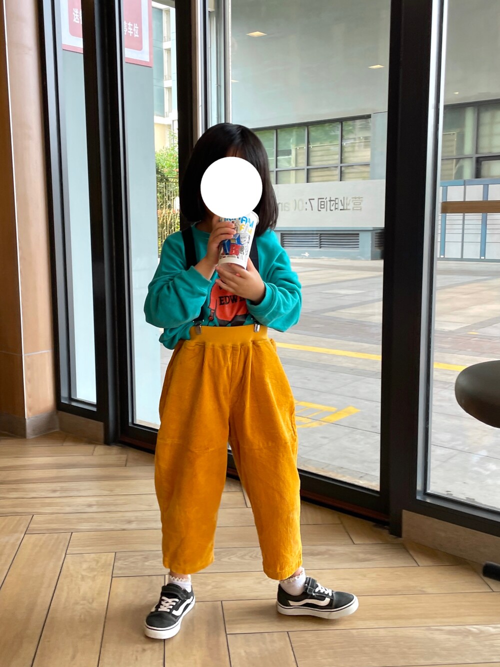 グリーン系のスウェット、イエロー系のパンツ、ブラック系のスニーカーを着用したキッズの春コーディネートの2枚目の写真