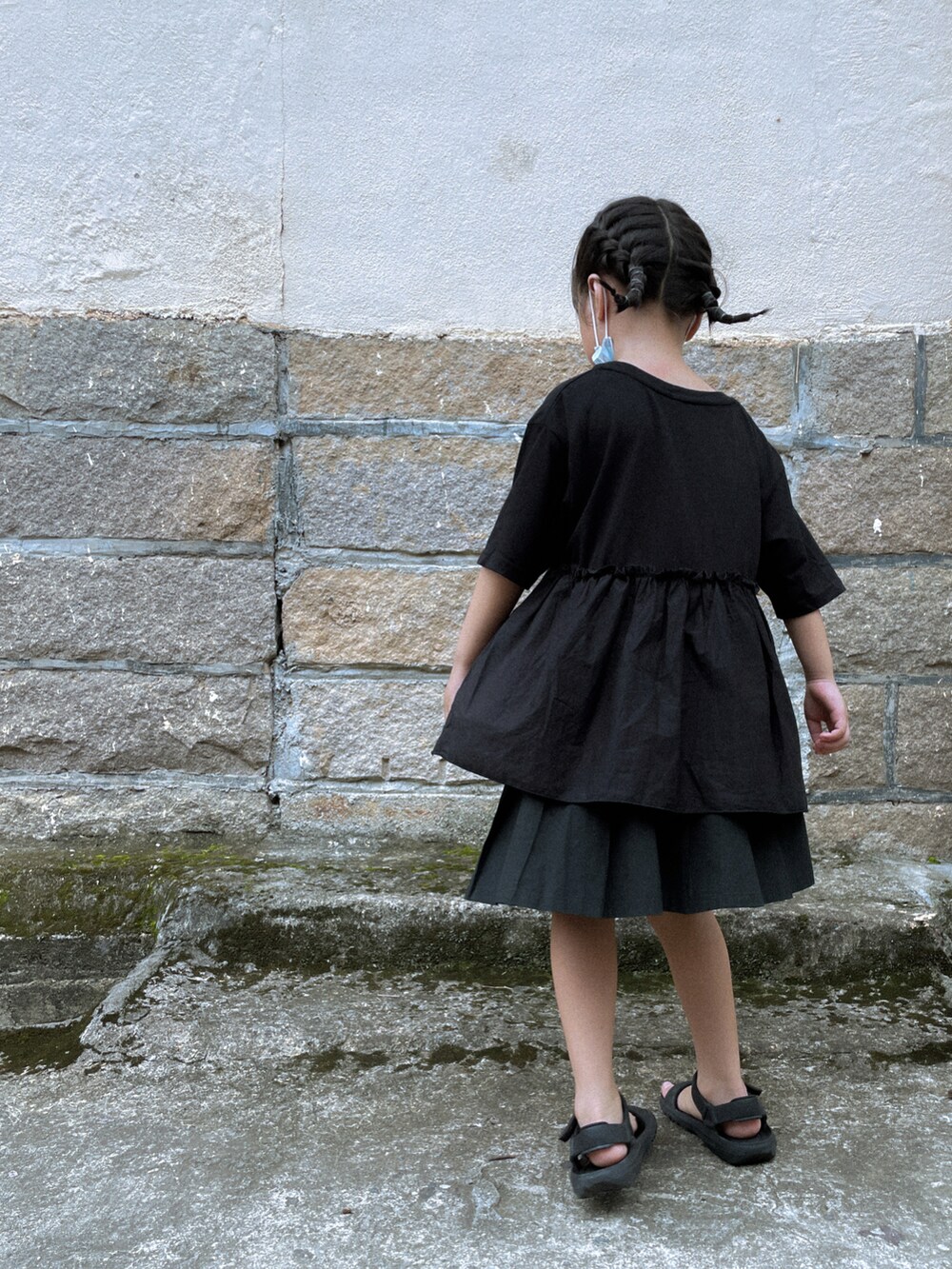 ブラック系のTシャツ/カットソー、ブラック系のスカート、ブラック系のサンダルを着用したキッズの夏コーディネートの2枚目の写真