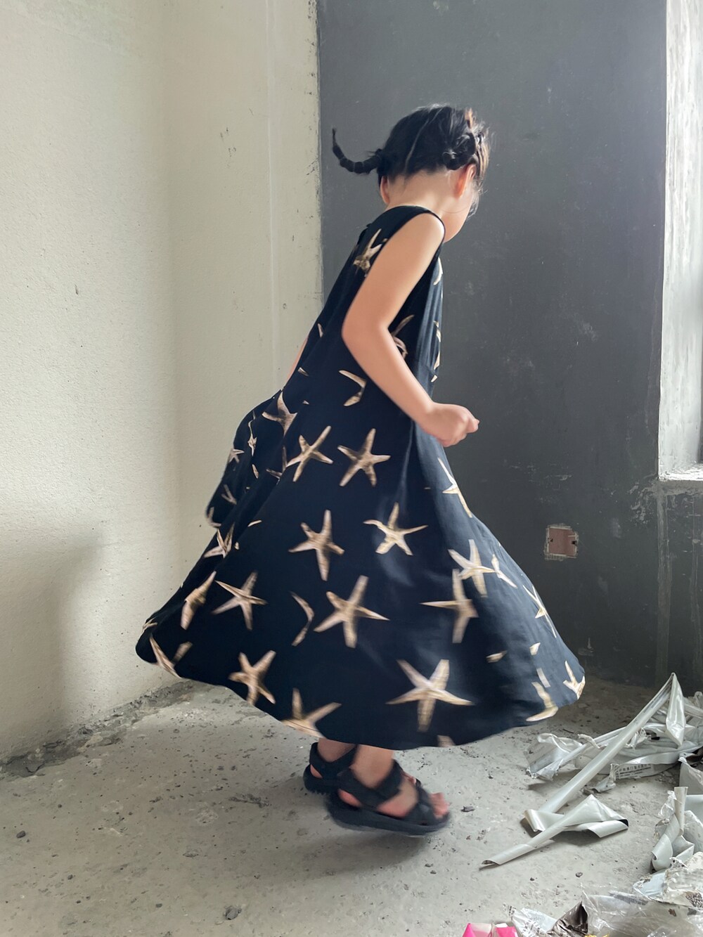 ブラック系のワンピース、ブラック系のサンダルを着用したキッズの夏コーディネートの2枚目の写真