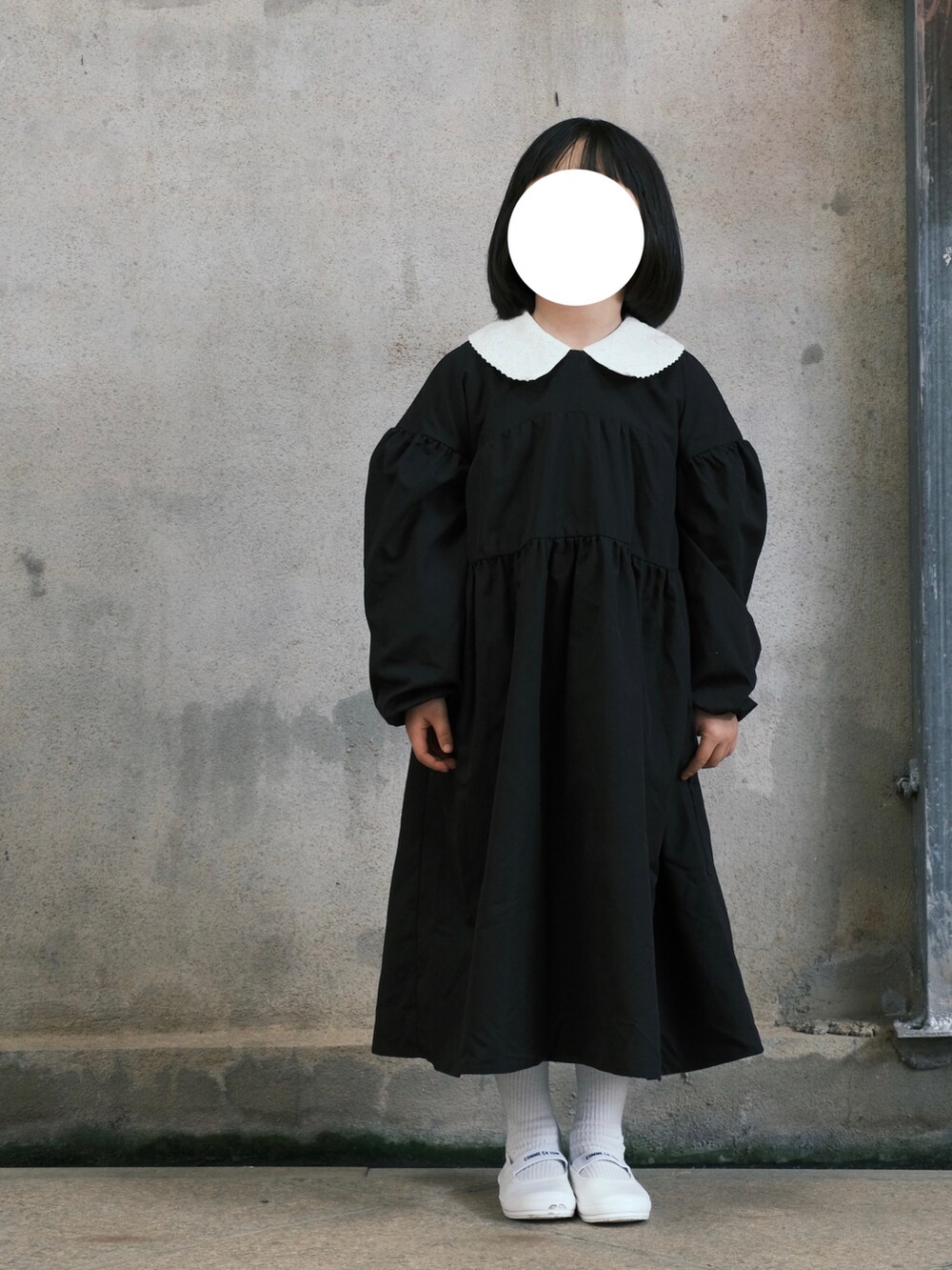 ブラック系のワンピース、イエロー系のジャケット/アウター、ホワイト系のシューズを着用したキッズの春コーディネートの3枚目の写真