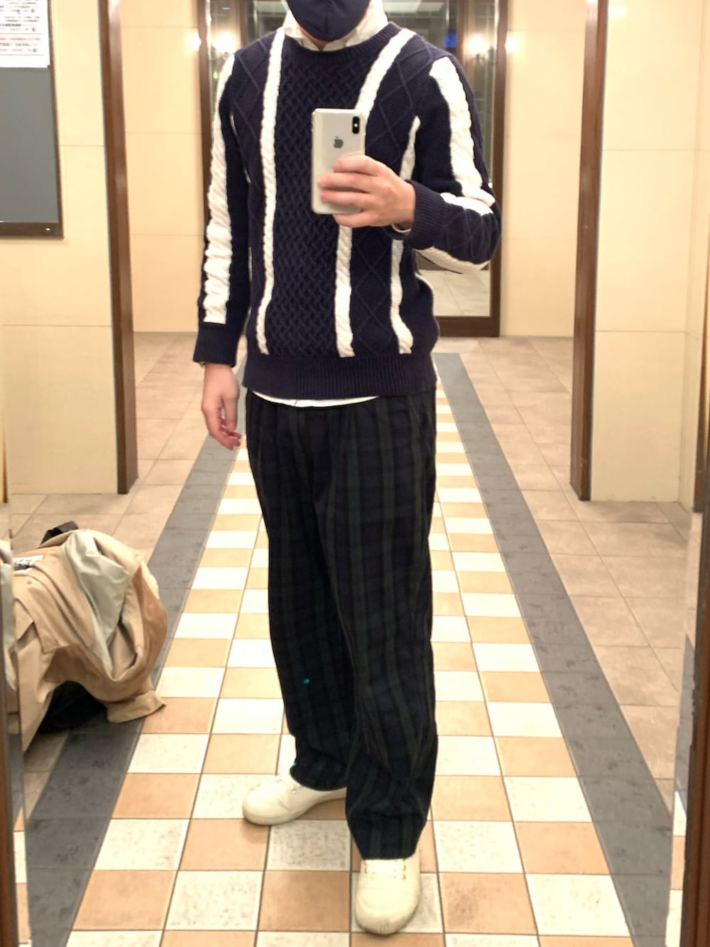 ベージュ系のステンカラーコート、ブルー系のニット/セーター、グリーン系のスラックスを着用したメンズの春コーディネートの2枚目の写真