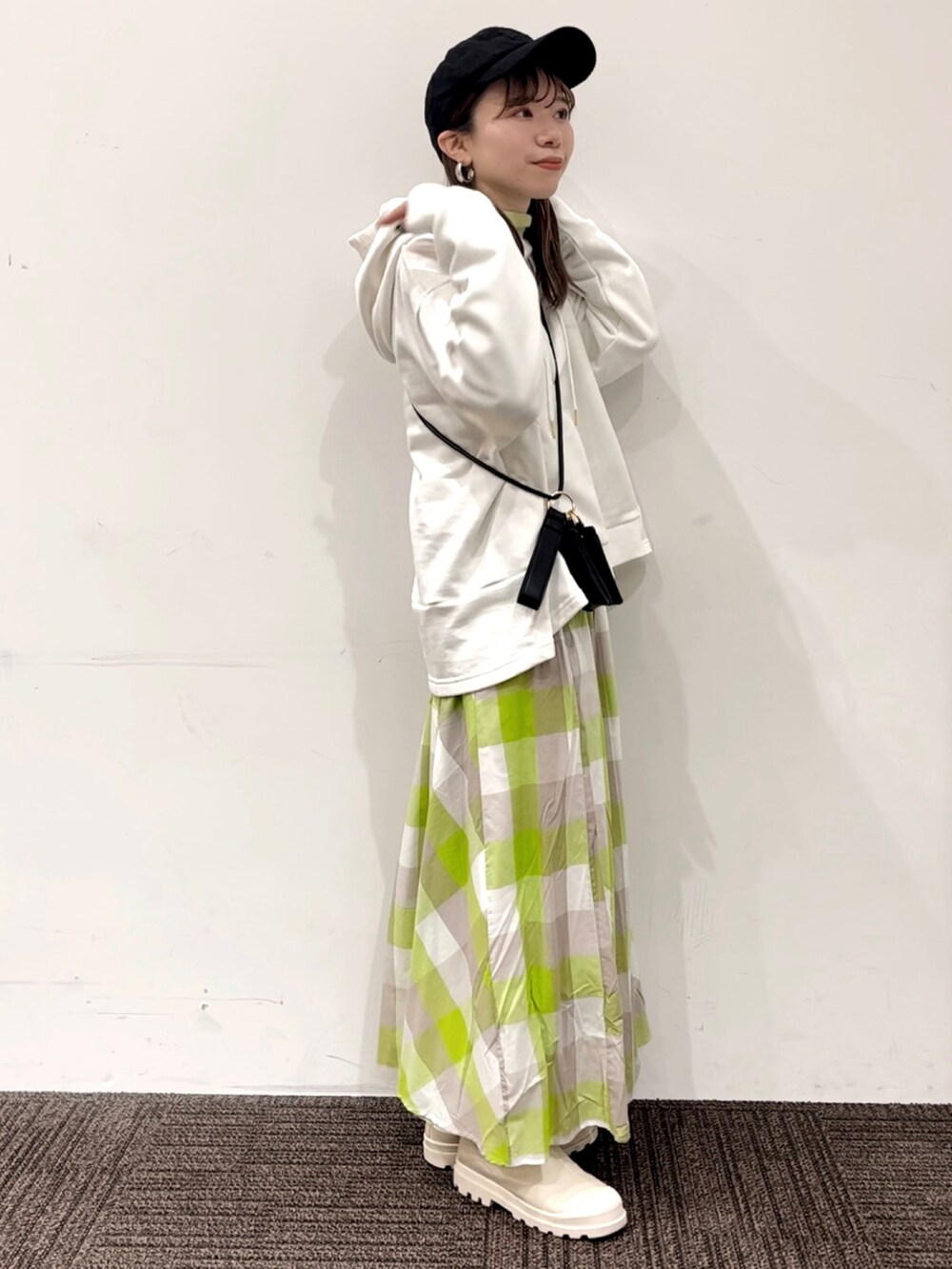 グリーン系のスカート、ホワイト系のTシャツ/カットソー、ホワイト系のブーツを着用したレディースの冬コーディネートの3枚目の写真