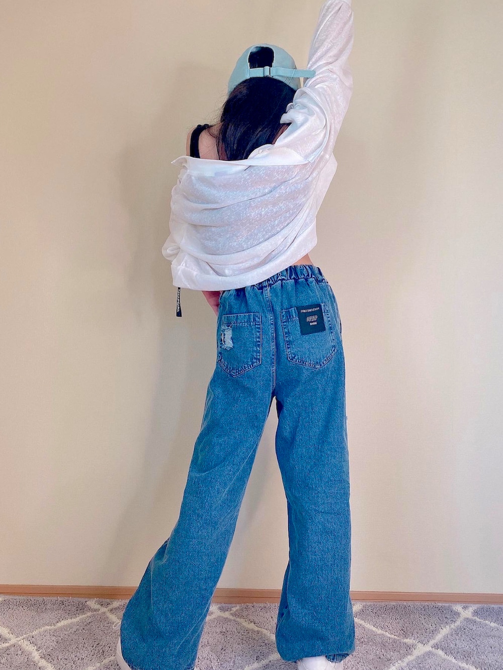 ブルー系のデニムパンツ、ホワイト系のブルゾン、ブラック系のキャミソールを着用したキッズの夏コーディネートの2枚目の写真
