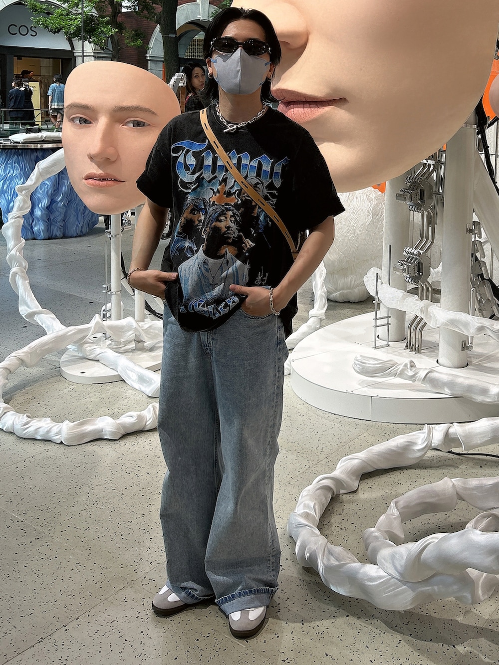 ブルー系のデニムパンツ、ホワイト系のスニーカー、ブラウン系のショルダーバッグを着用したメンズの夏コーディネートの3枚目の写真