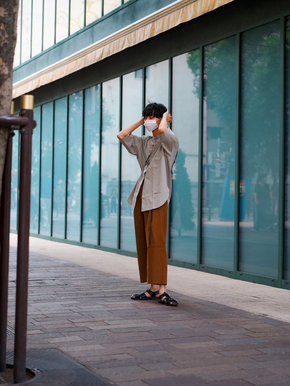 ブラック系のショルダーバッグ、オレンジ系のその他パンツ、ブラック系のサンダルを着用したメンズの夏コーディネートの3枚目の写真