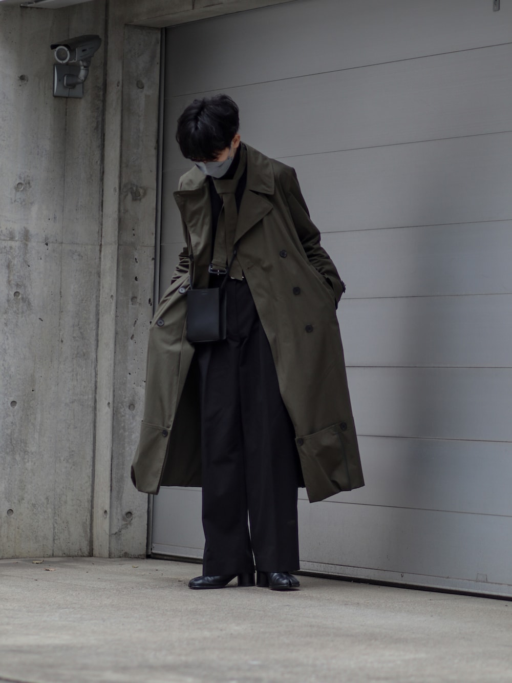 ブラック系のブーツ、ブラック系のスラックス、グリーン系のジャケット/アウターを着用したメンズの春コーディネートの2枚目の写真