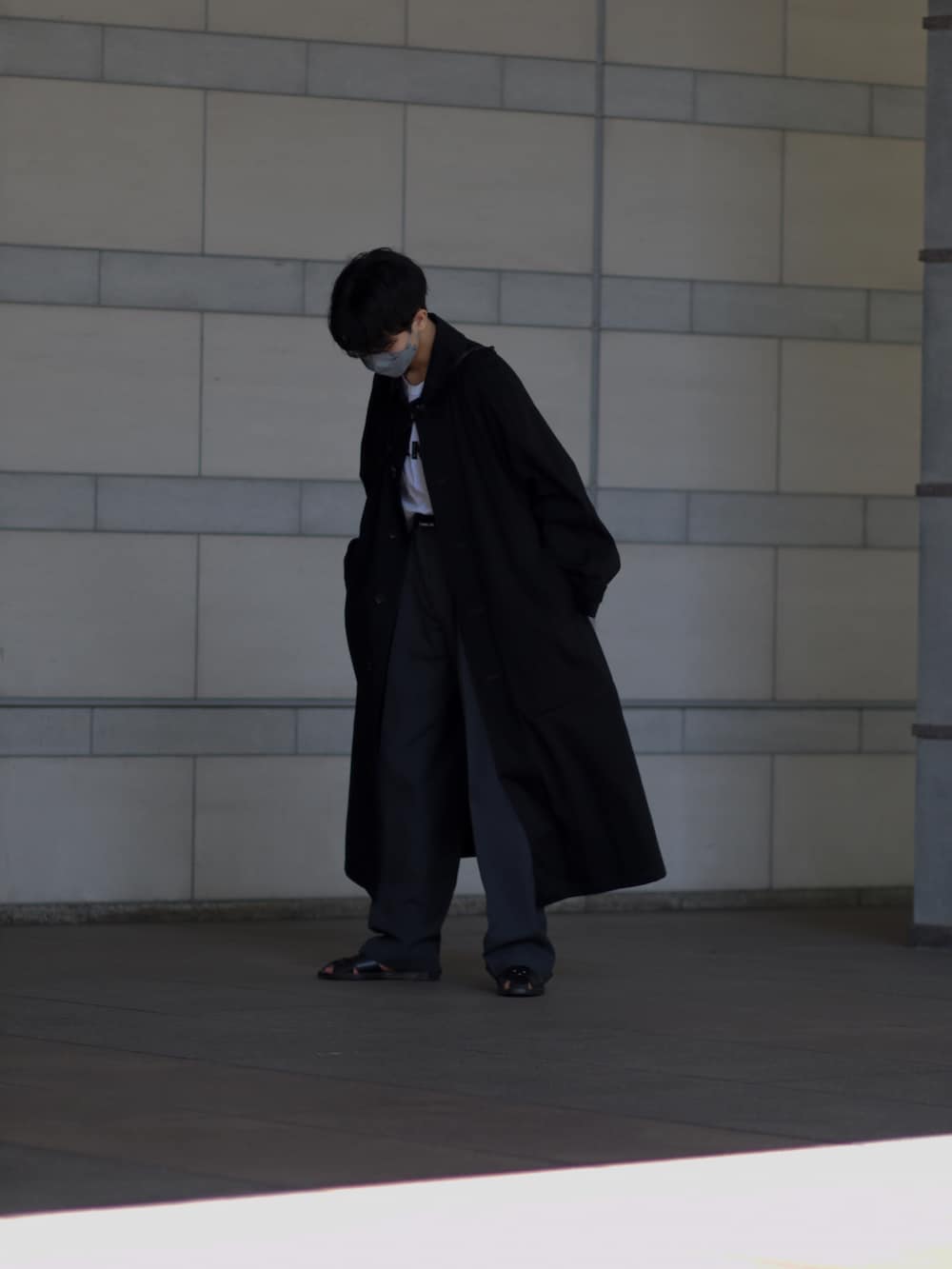 ブラック系のその他アウター、ブラック系のスラックス、ブラック系のサンダルを着用したメンズの春コーディネートの2枚目の写真