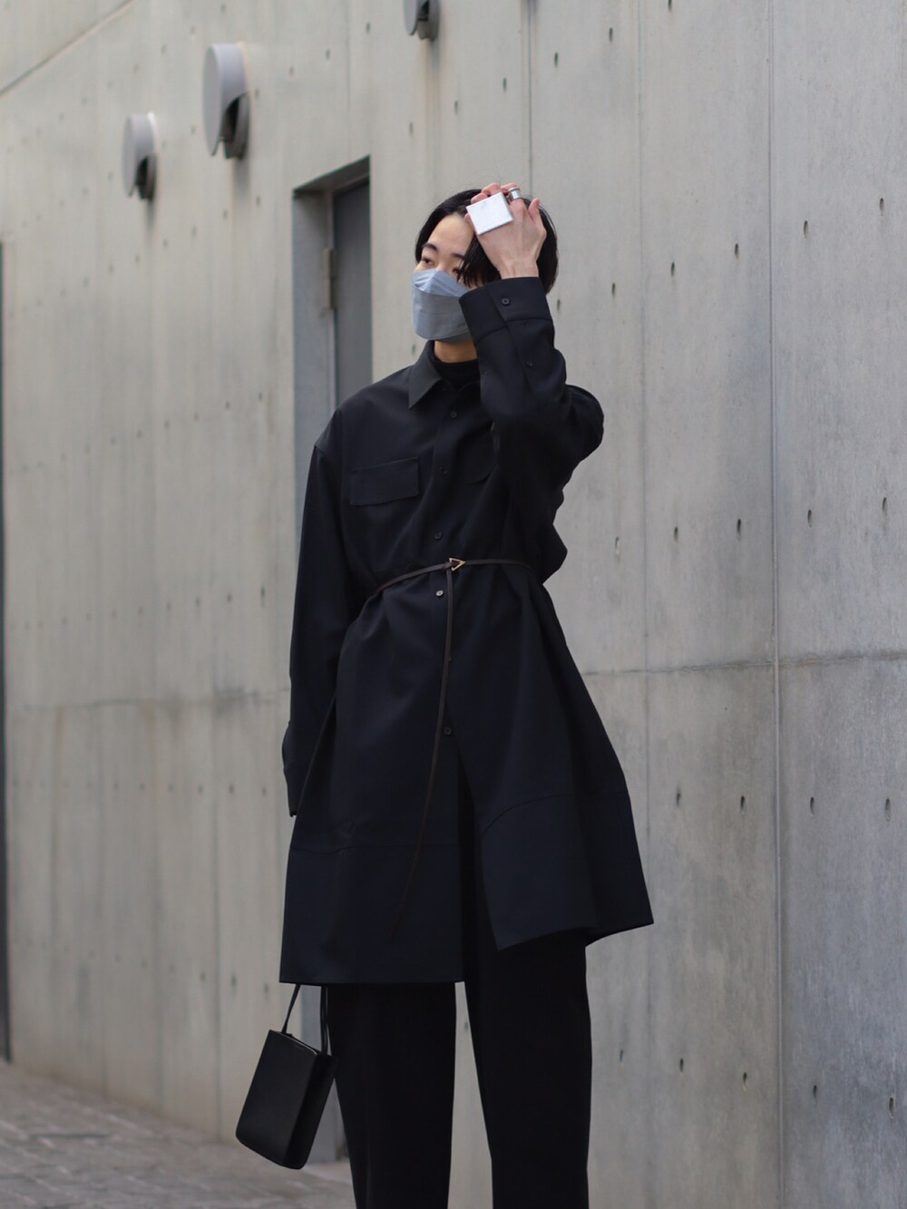 ブラック系のブーツ、ブラック系のスラックス、ブラック系のショルダーバッグを着用したメンズの冬コーディネートの2枚目の写真